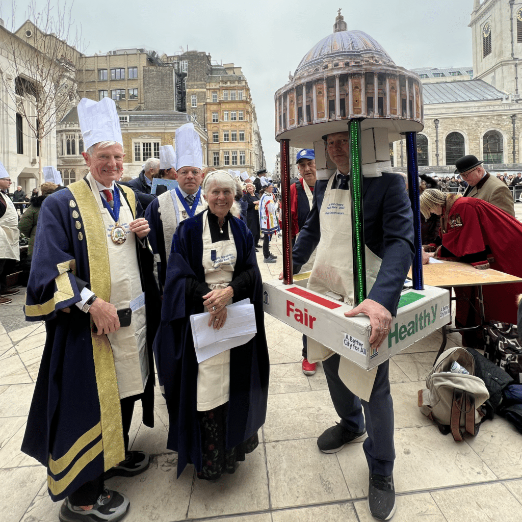 People dressed in costumes smiling at camera for pancaking event at Guildhall